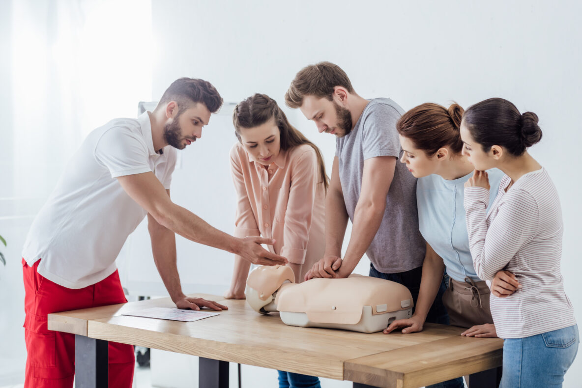 A group of people learning CPR from an instructor.