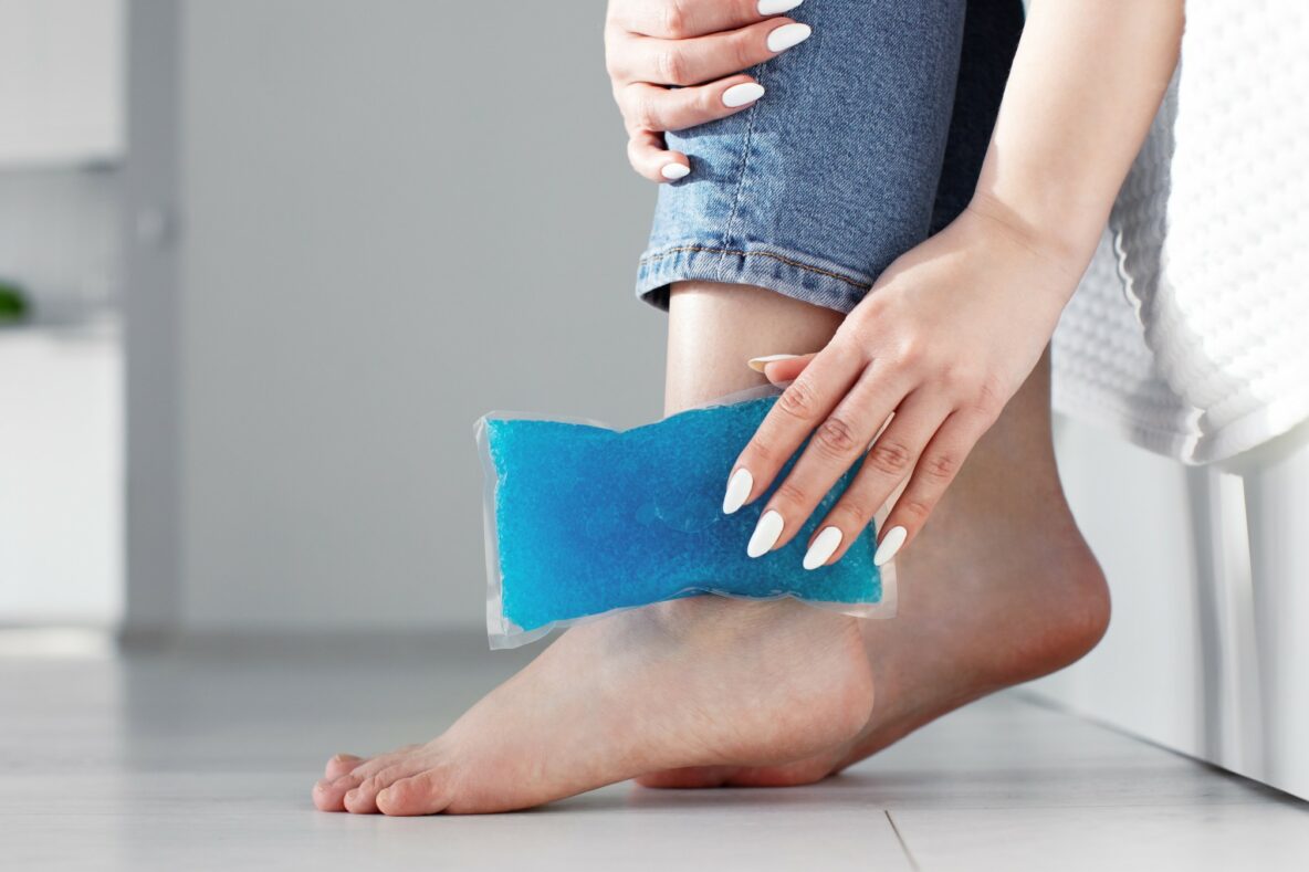 Woman icing ankle injury with an ice pack.