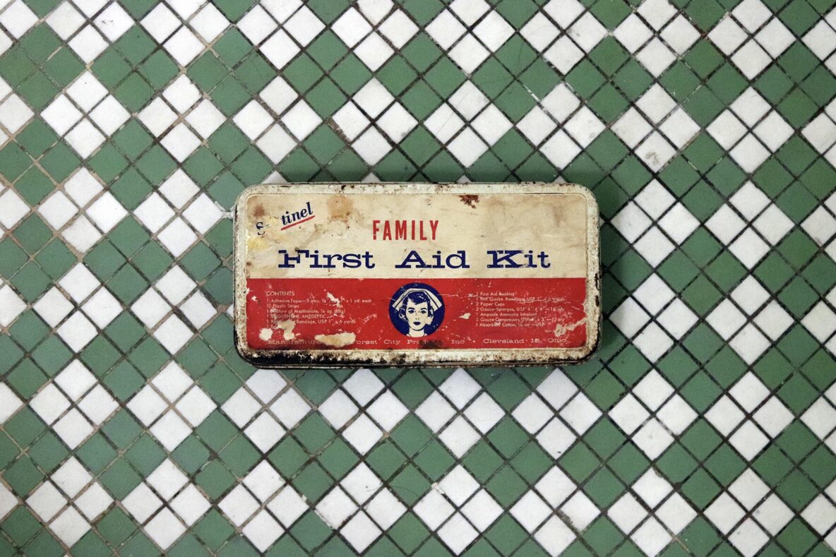 Rusty and old first aid kit on a diamond print background