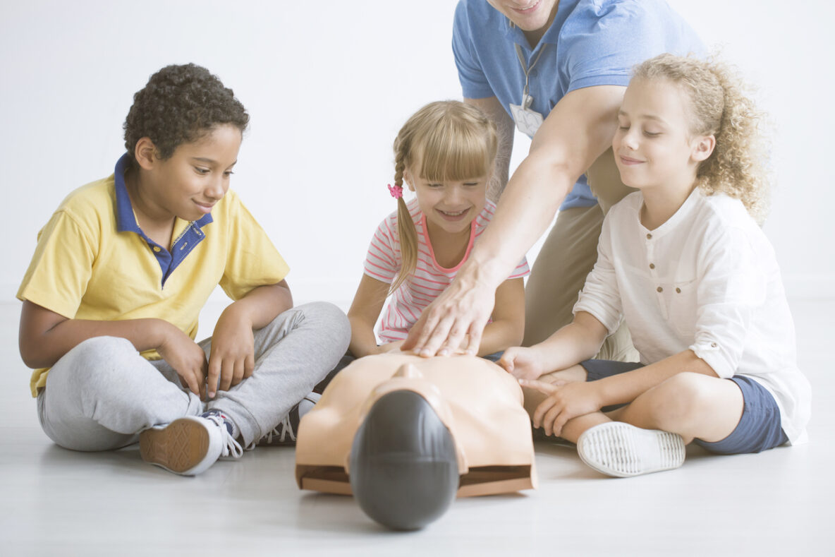 Kids learning CPR from an instructor.